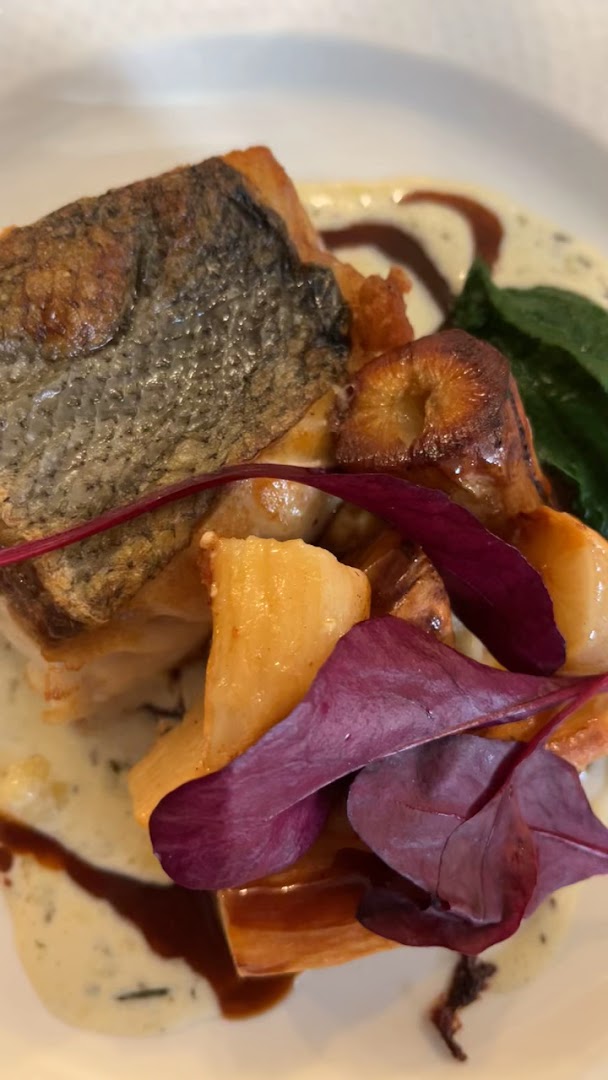 Un poisson rôti accompagné de légumes et de jeunes pousses