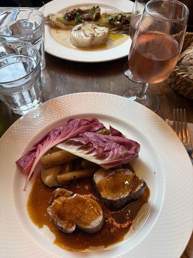Une assiette de viande en sauce avec légumes et salade